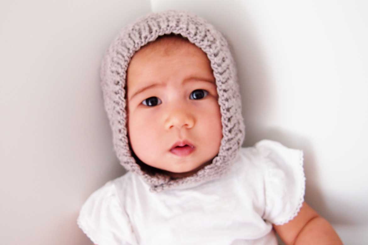 Free Baby Knitting Pattern | This cute bonnet hat is a free sewing pattern and makes a great beginner knitting project.